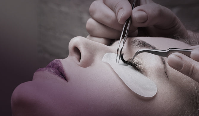 Lash technician helps to curl eyelash with tweezers for extensions